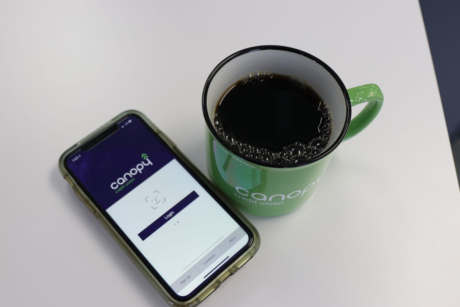 phone with canopy app open next to cup of coffee