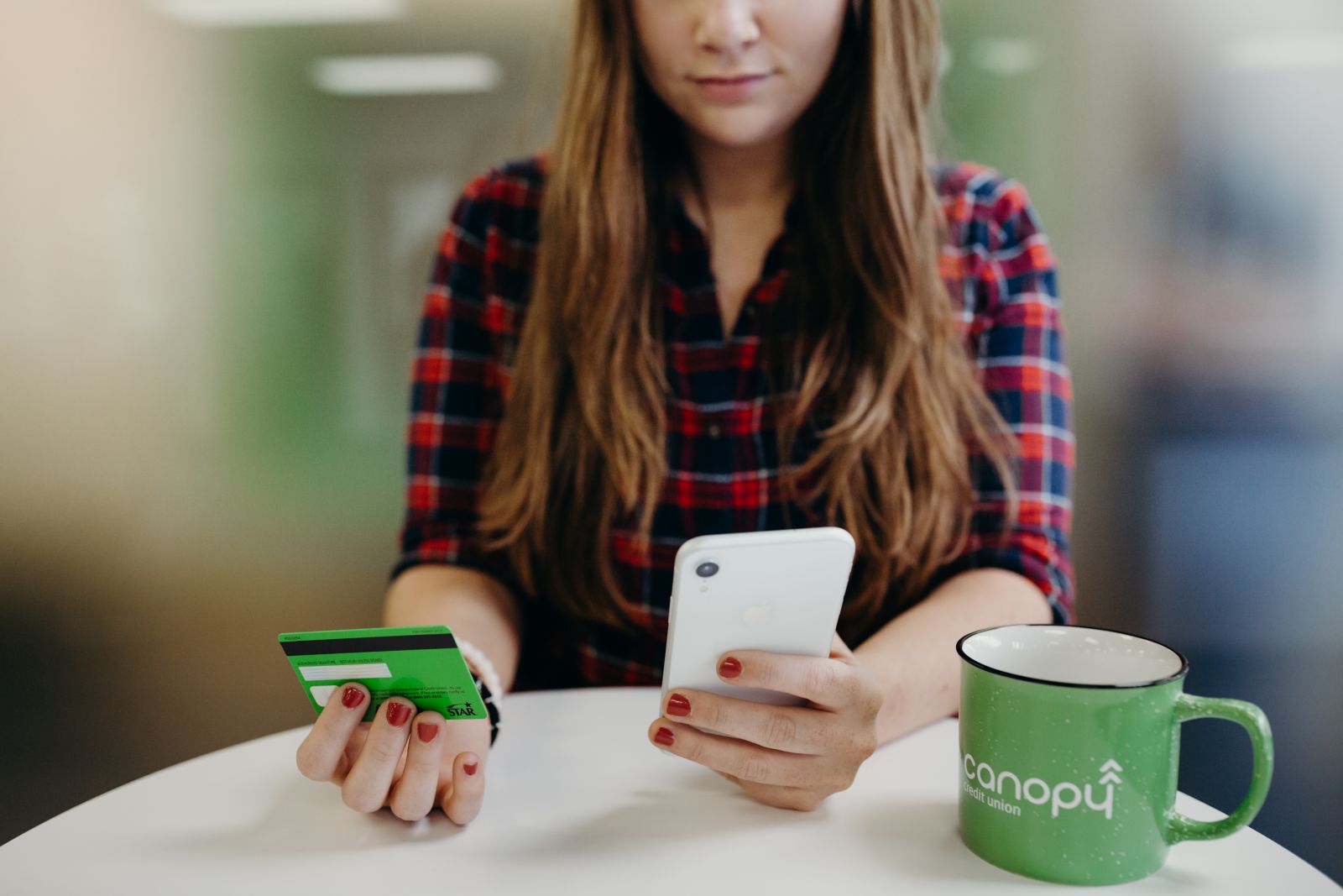 woman with canopy mug checking bank account on mobile canopy app