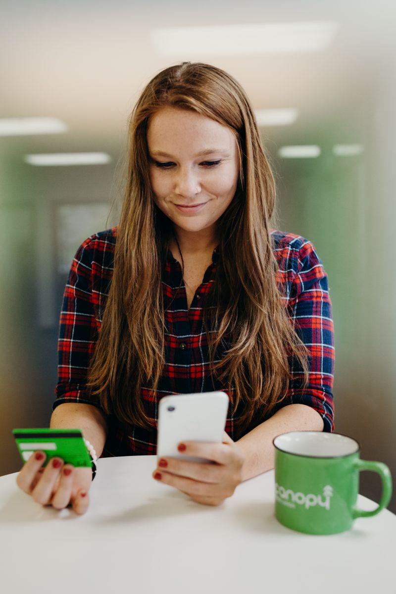 woman using canopy app while holding card