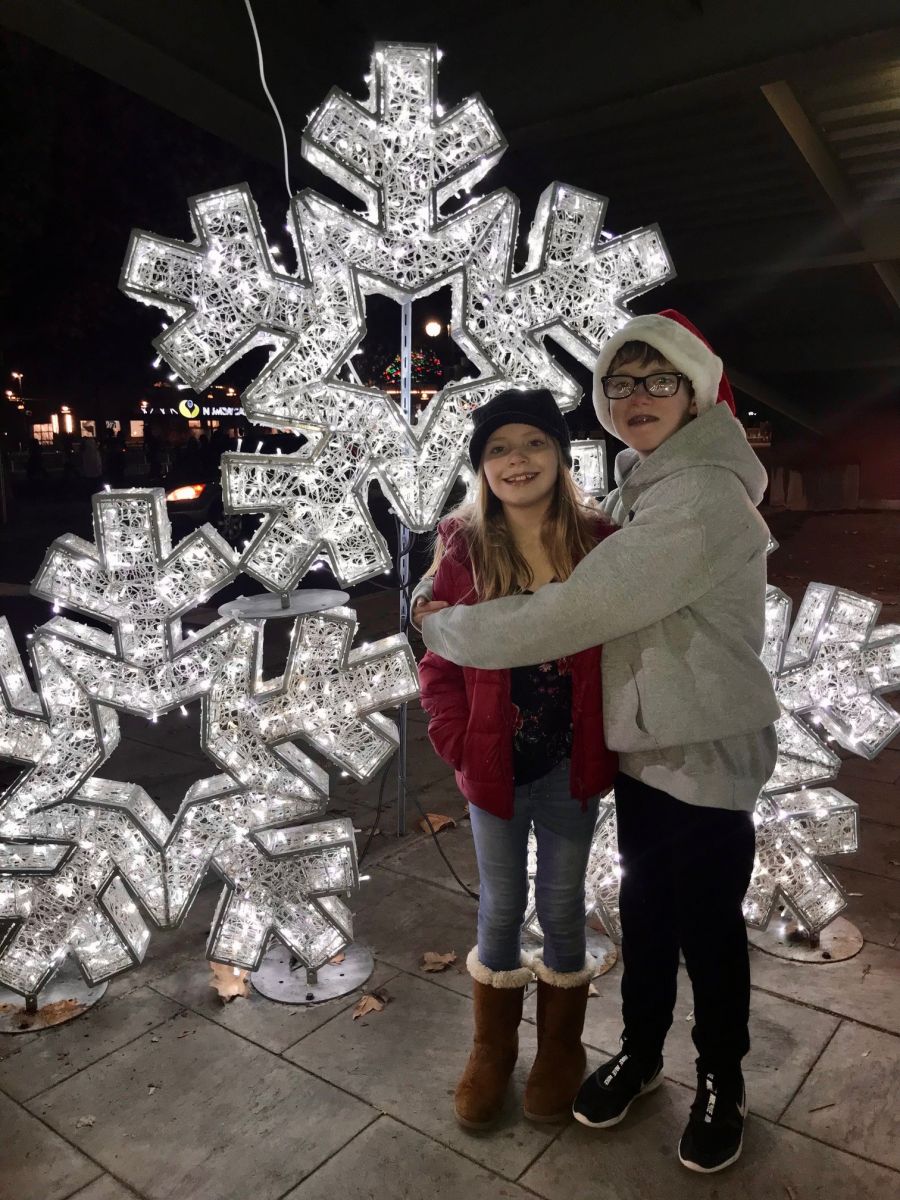 picture of two children standing in front of light up snowflake