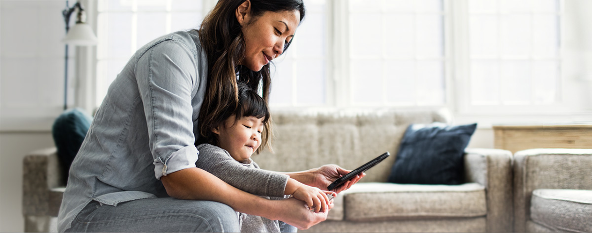 mother using online banking while holding daughter